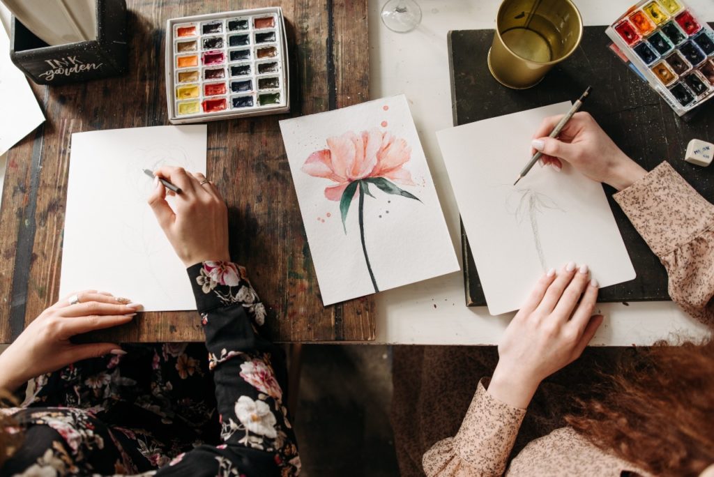two women painting with watercolors